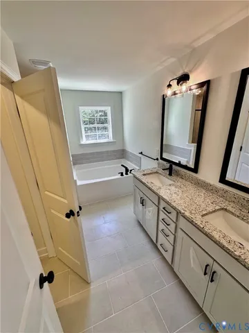 a spacious bathroom with a tub sink and mirror