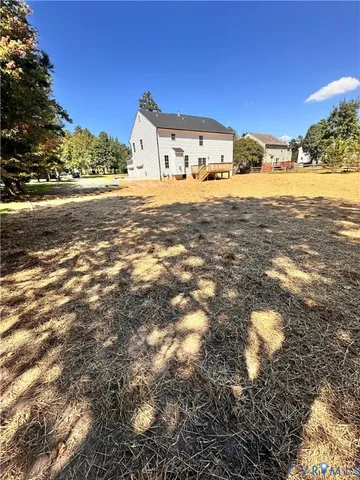 a big yard with a large tree and yard in front of it