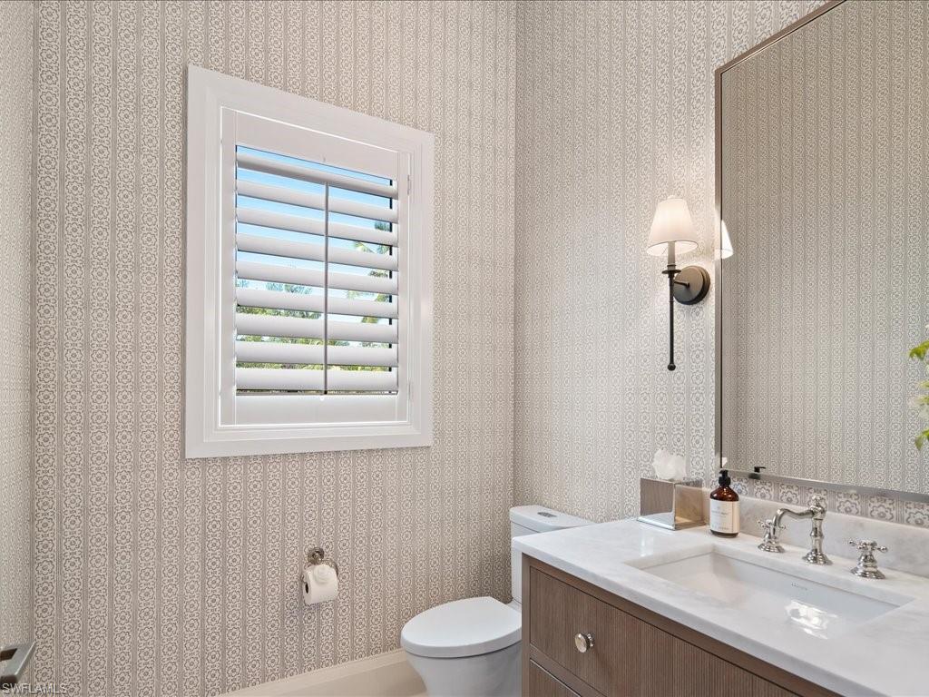 142 Eugenia Drive Naples, FL 34108 - Photo 16 of 35 a bathroom with a granite countertop sink a toilet and a mirror