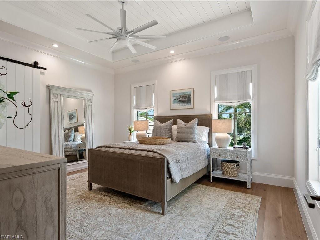 142 Eugenia Drive Naples, FL 34108 - Photo 23 of 35 a bedroom with a bed and a chandelier