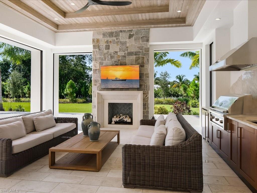 142 Eugenia Drive Naples, FL 34108 - Photo 29 of 35 a living room with furniture a fireplace and a floor to ceiling window