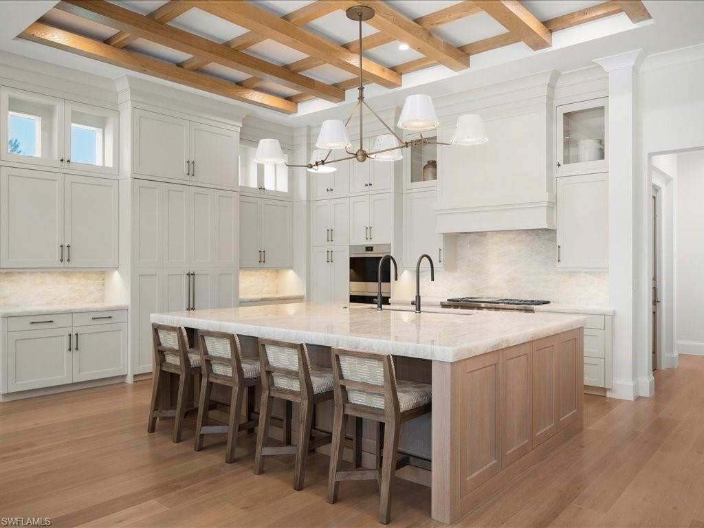 142 Eugenia Drive Naples, FL 34108 - Photo 6 of 35 a kitchen with a table chairs stove and cabinets