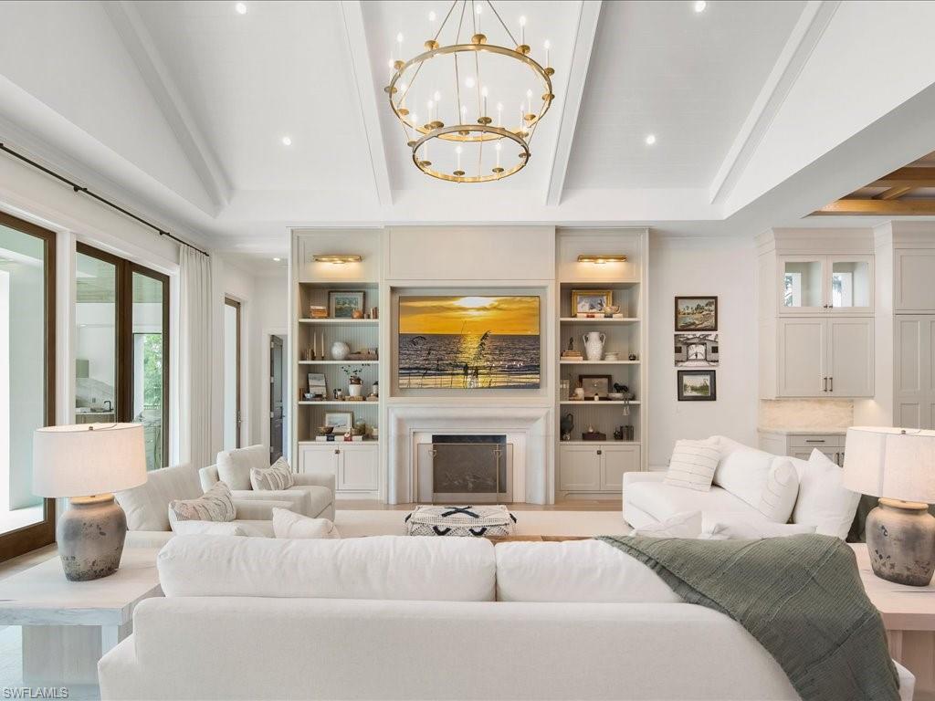 142 Eugenia Drive Naples, FL 34108 - Photo 9 of 35 a living room with furniture a fireplace and a flat screen tv