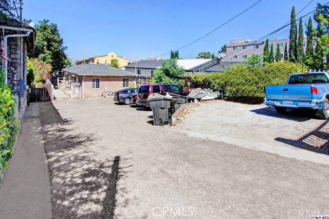 a view of a patio with table and chairs potted plants & large tree