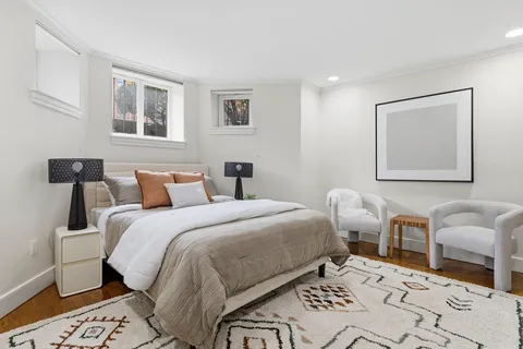 a bedroom with bed and a painting on the wall