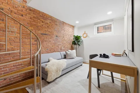 a living room with furniture and a potted plant
