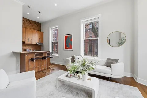 a living room with furniture a computer on a desk and chair