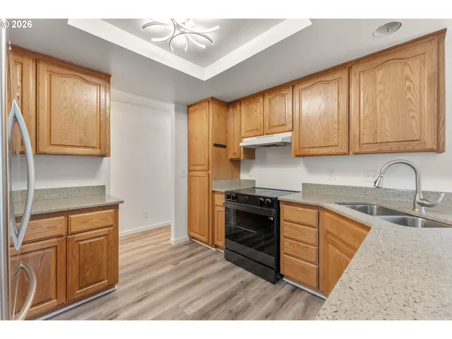 a kitchen with stainless steel appliances granite countertop a sink stove and refrigerator