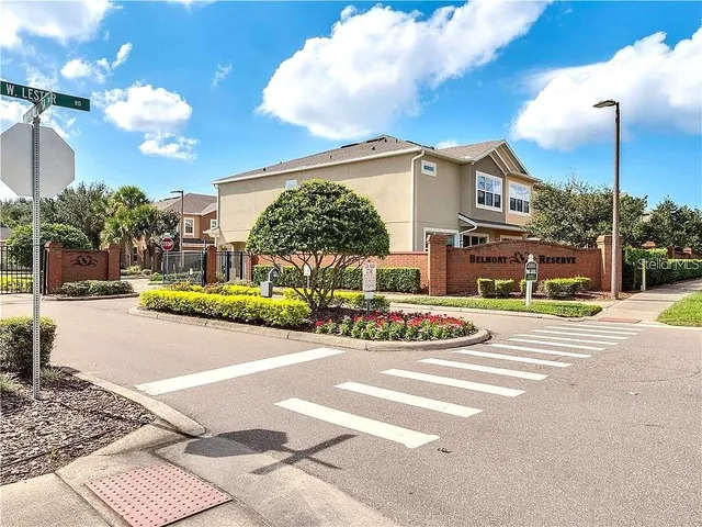 a living room with couches and kitchen view with wooden floor