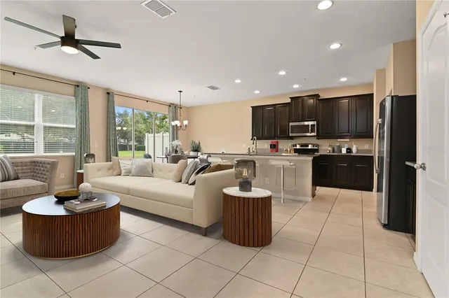 a living room with furniture a flat screen tv and a window