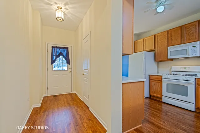 a view of a kitchen with a stove wooden floor a sink and a window