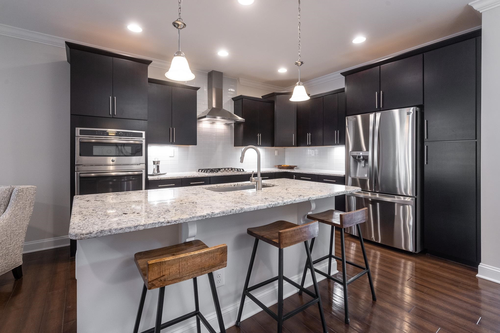 712 Fallon Grove Way Raleigh, NC 27608 - Photo 5 of 20 a kitchen with stainless steel appliances kitchen island granite countertop a kitchen island and chairs in it