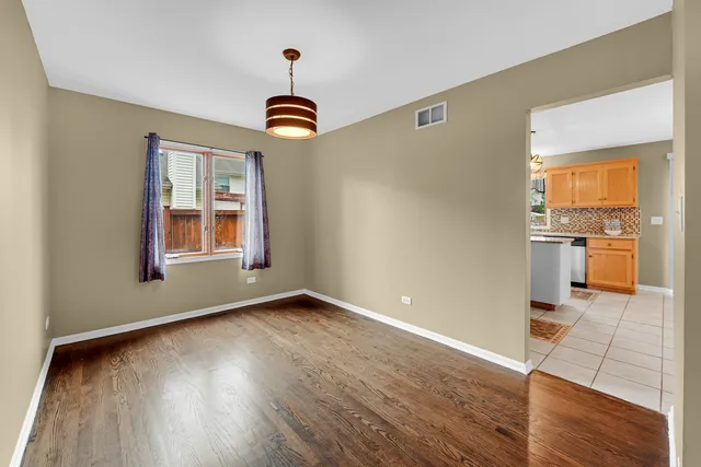 a view of a kitchen with wooden floor electronic appliances and furniture