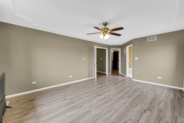 a view of room with wooden floor and ceiling fan
