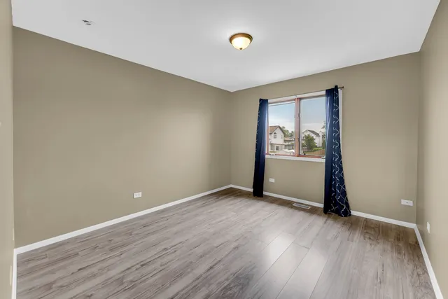 an empty room with wooden floor and entrance