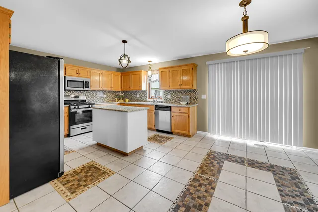 a kitchen with stainless steel appliances granite countertop a stove a sink and a refrigerator