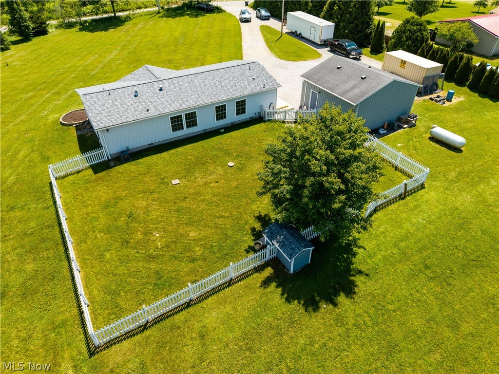 294 Twp 150 Road Sullivan, OH 44880 - Photo 34 of 39 Expansive green lawn featuring a white picket fence, a mature shade tree, and a small storage shed