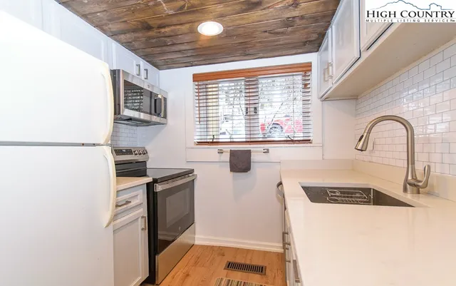 a kitchen with a refrigerator and a stove