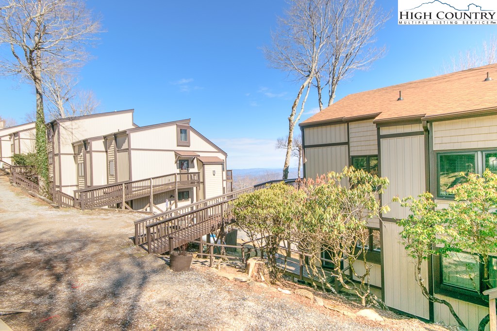 220 Northridge Road, Unit 25 Beech Mountain, NC 28604 - Photo 2 of 47 a view of a house with a large tree and flower plants