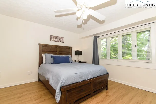 a bedroom with a bed and a ceiling fan