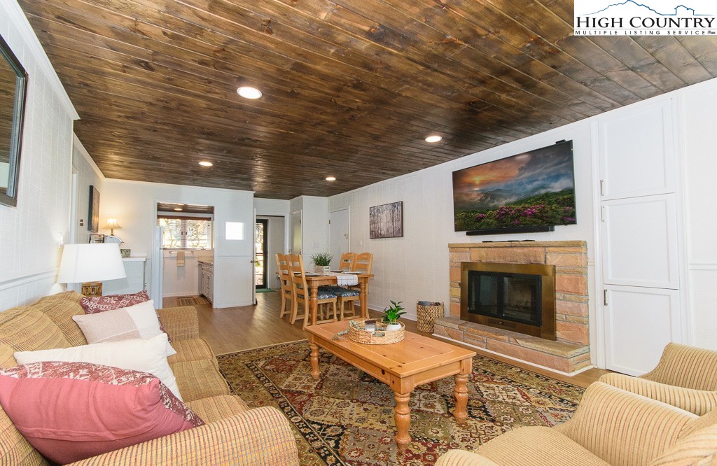 220 Northridge Road, Unit 25 Beech Mountain, NC 28604 - Photo 6 of 47 a living room with furniture a flat screen tv and a fireplace
