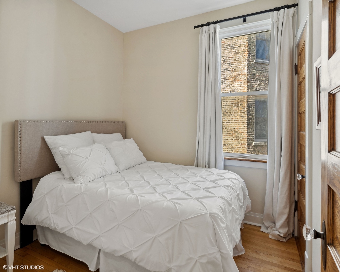 1920 West Addison Street Chicago, IL 60613 - Photo 22 of 34 a large white bed in a small room next to a window