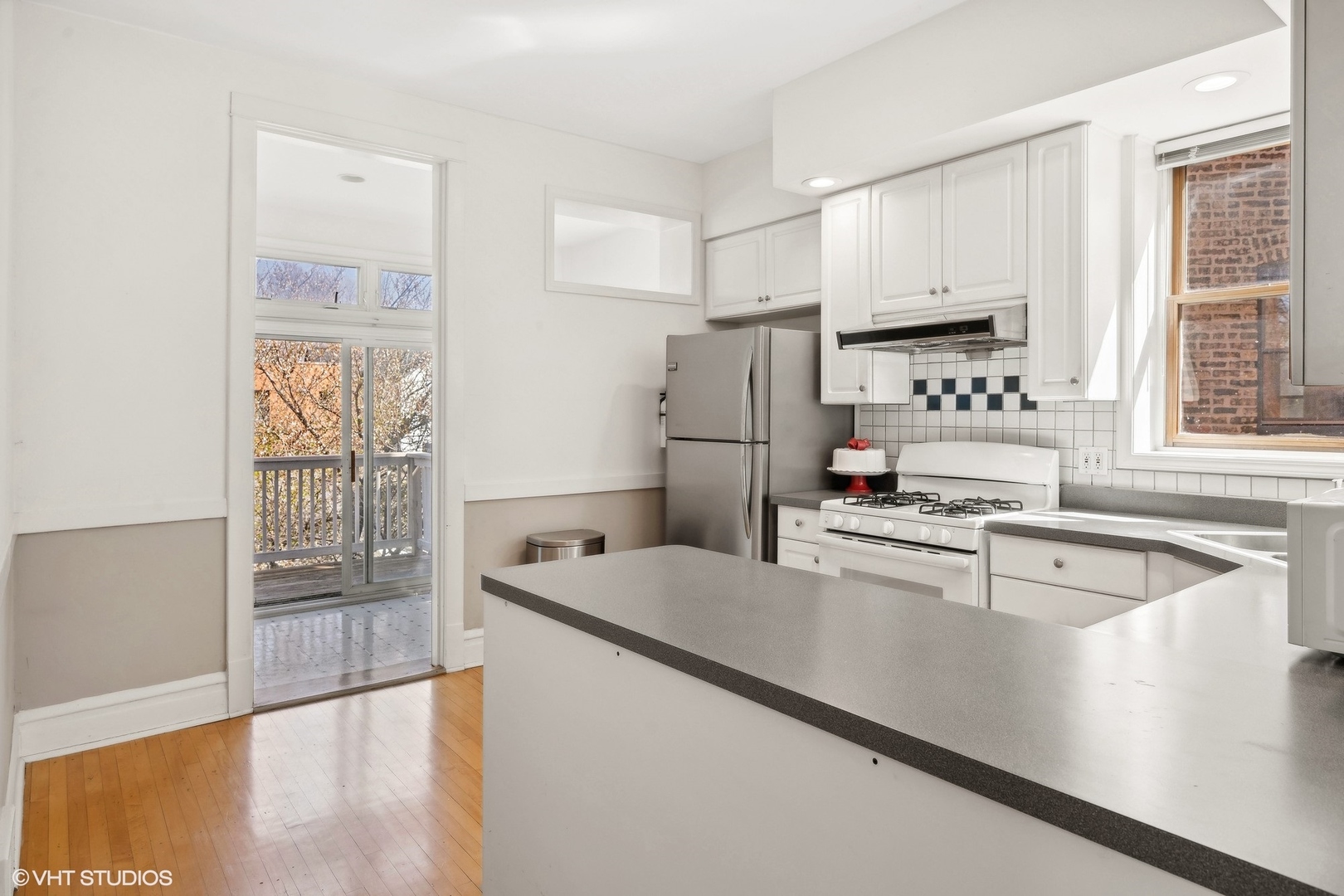 1920 West Addison Street Chicago, IL 60613 - Photo 25 of 34 a kitchen with stainless steel appliances granite countertop a refrigerator a stove and a sink with wooden floor