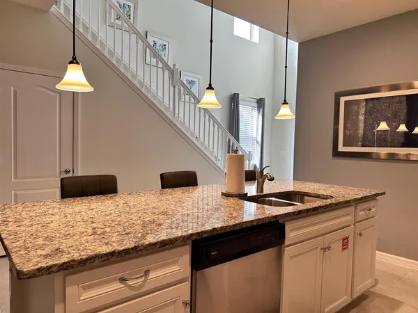 a kitchen with stainless steel appliances granite countertop a sink a refrigerator and a stove