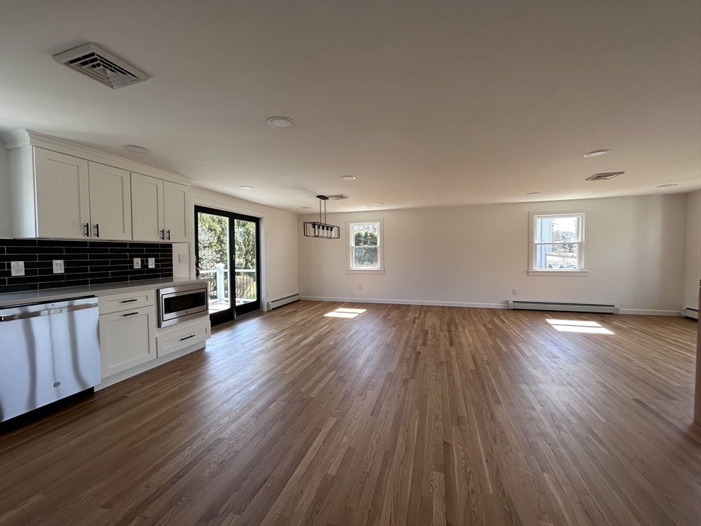 585 North Eastern Avenue Fall River, MA 02720 - Photo 10 of 26 a view of a kitchen with an empty room and wooden floor