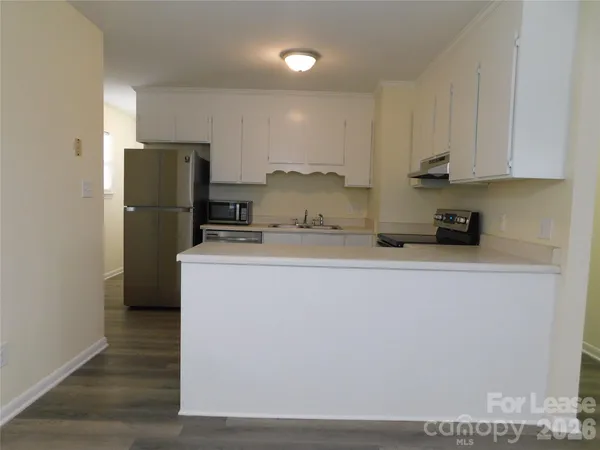 a kitchen with a refrigerator a stove a microwave and cabinets
