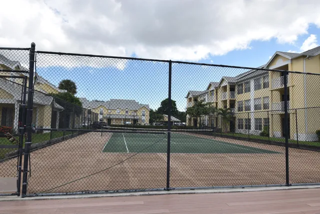 a view of a brick house with wooden fence