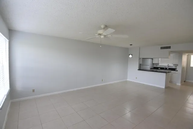 a kitchen with granite countertop cabinets sink and a refrigerator