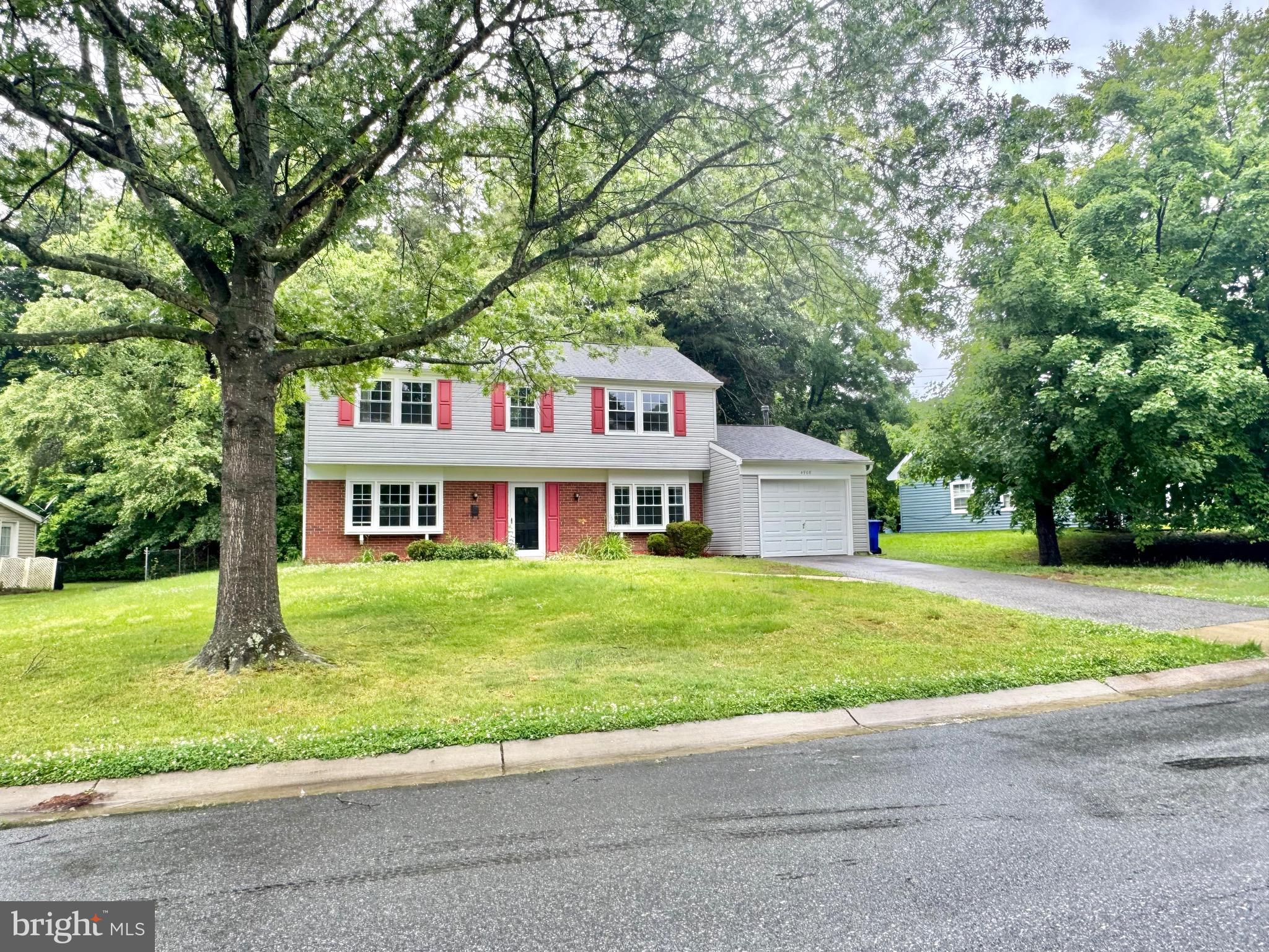 4908 Rocky Spring Lane Bowie, MD 20715 - Photo 36 of 36 a front view of a house with a yard and trees