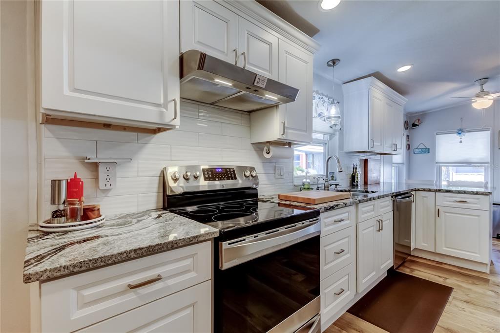 7 Frangipani Circle, Unit 7 Largo, FL 33770 - Photo 12 of 45 a kitchen with stainless steel appliances granite countertop a stove and cabinets