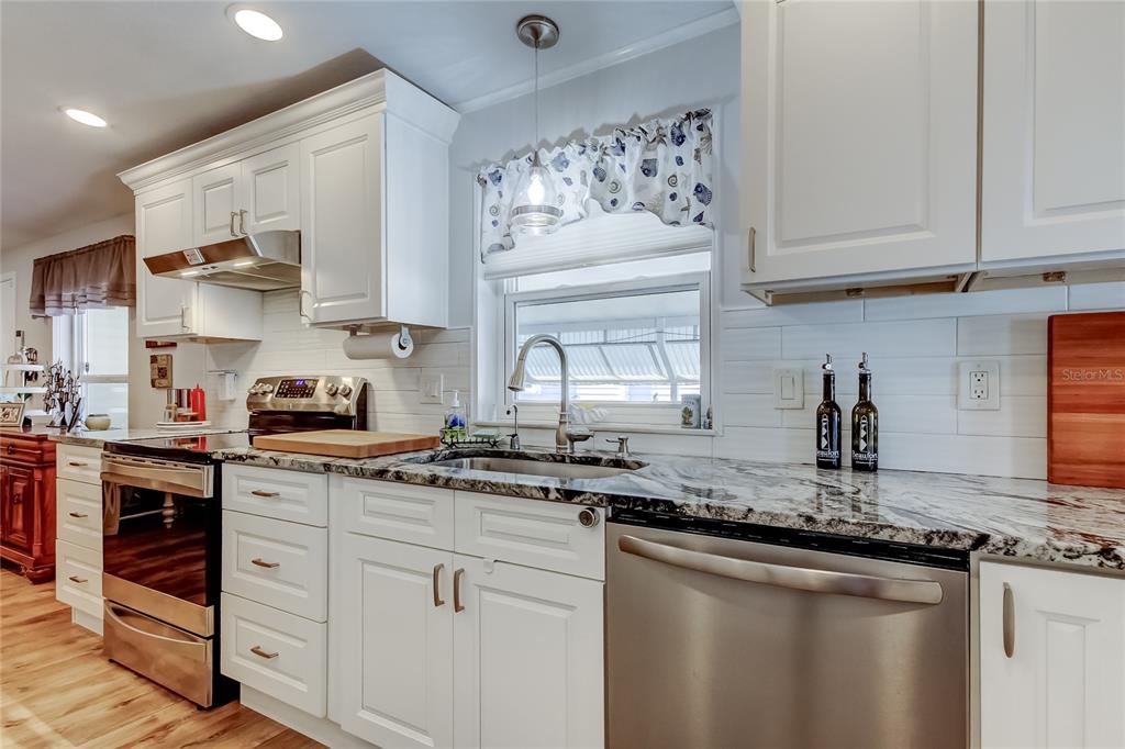 7 Frangipani Circle, Unit 7 Largo, FL 33770 - Photo 17 of 45 a kitchen with stainless steel appliances granite countertop a sink stove and cabinets