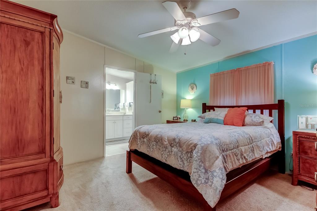 7 Frangipani Circle, Unit 7 Largo, FL 33770 - Photo 23 of 45 a bedroom with a large bed and a chandelier