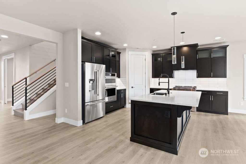 2422 242nd Place Southeast, Unit 12 Bothell, WA 98021 - Photo 3 of 25 a kitchen with stainless steel appliances kitchen island a sink and a refrigerator