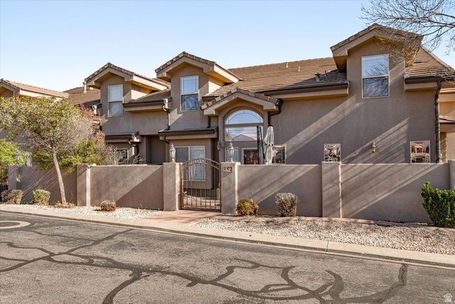 345 North 2450th Street East, Unit 152 St. George, UT 84790 - Photo 2 of 40 View of front of property featuring a fenced front yard, a gate, stucco siding, and a tile roof