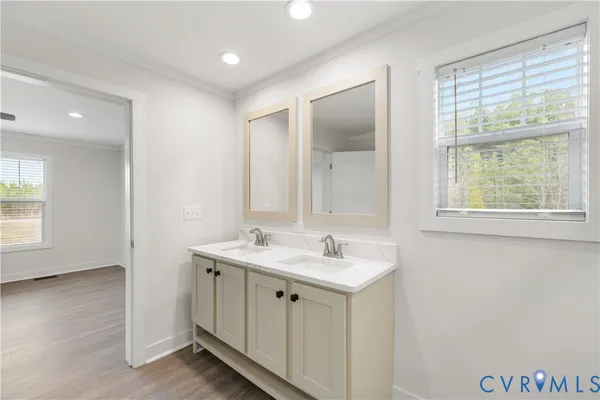 a spacious bathroom with a granite countertop sink a toilet and a large mirror