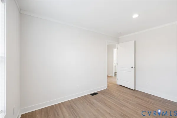 an empty room with wooden floor and window