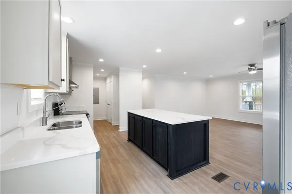 a kitchen with a sink cabinets and wooden floor