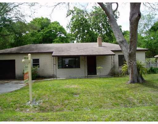 a view of a house with a yard and tree