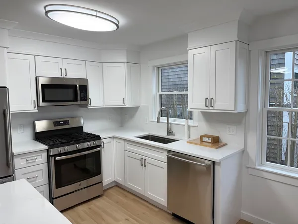 a kitchen with a table chairs sink refrigerator and cabinets