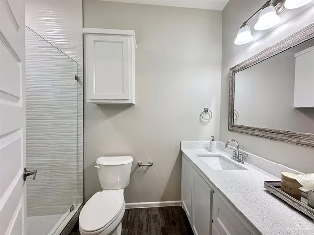 a bathroom with a granite countertop toilet sink and mirror