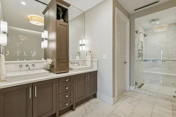 a bathroom with a sink vanity granite shower and a mirror