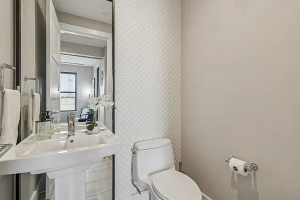 a bathroom with a toilet a sink and mirror