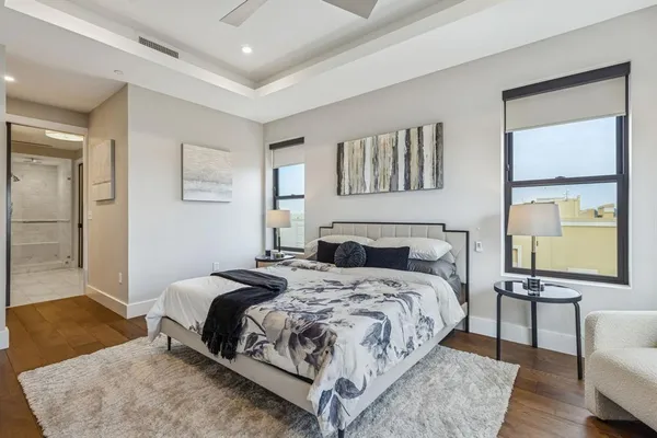 a bedroom with a bed a mirror and a potted plant