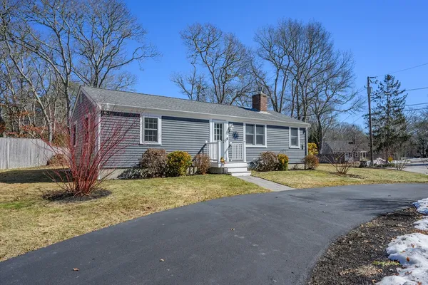 a view of a house with a yard and large tree
