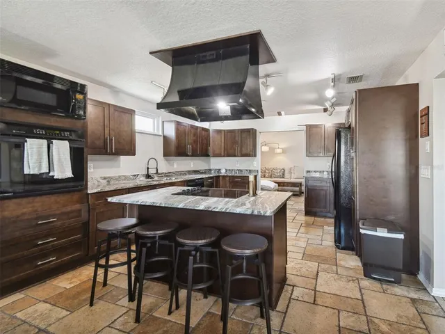 a kitchen with stainless steel appliances granite countertop a refrigerator and a sink