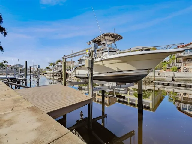 a dining room with wooden floor a chandelier a wooden table and chairs